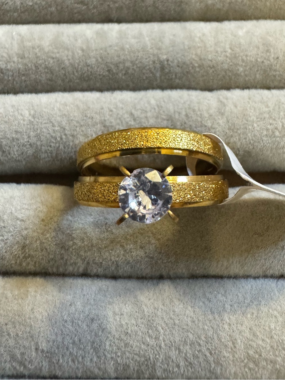 Gold-Tone Solitaire Engagement Ring with Textured Bands and Clear Stone
